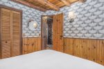 Cozy linens and custom wallpaper complete this stylish retreat